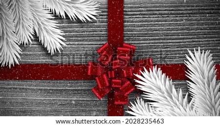 Image of christmas red present ribbon with snow falling on grey. christmas celebration festivity concept digitally generated image.