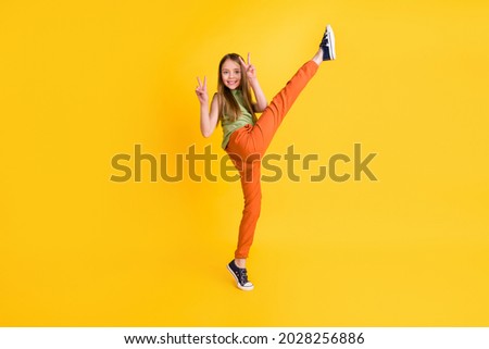 Full body photo of funny blond small girl do sport v-sign wear blouse trousers isolated on yellow color background