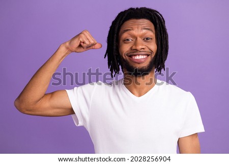Photo of cheerful happy dark skin man raise hand show muscles flex power isolated on violet color background