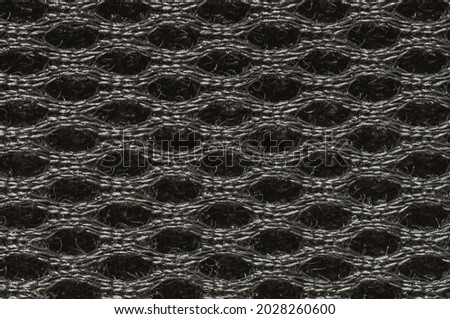 Closeup on fabric. Symmetrical net  texture or wallpaper. Oval, ring shape. Interesting design. Original fabric pattern.  Dark grunge net background. Black and white fibers macro photography.