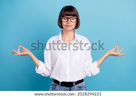 Portrait of attractive dreamy calm girl meditating hobby free time isolated over vibrant blue color background