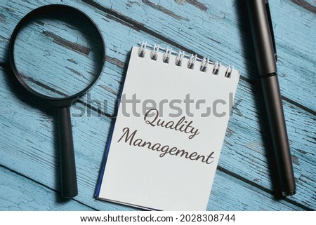 Top view of books with Quality Management wording. Business concept
