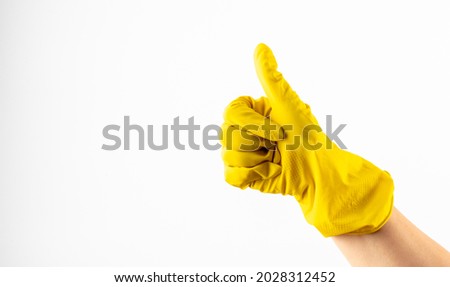 yellow glove for cleaning on arm show thumbs up. Yellow glove for cleaning  show thumbs up, isolated over white. Hand in yellow rubber glove, cleaning concept, gesture symbol ok, thumb up,  Royalty-Free Stock Photo #2028312452