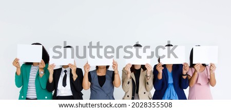 Studio shot of incognito unidentified unrecognizable faceless group of female office staff in business wears stand hold blank empty paper sign cover face for advertisement text on white background.