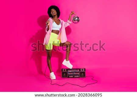 Photo of adorable funny dark skin lady wear casual shirt standing boom box singing holding disco ball isolated pink color background