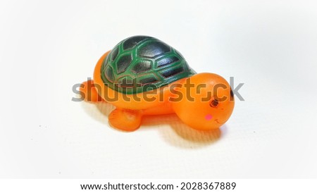isolated orange and green turtle rubber toy