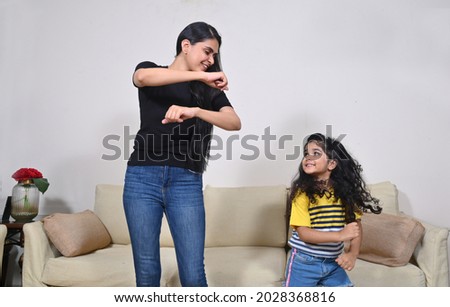 Female dance teacher teaching dance to little girl