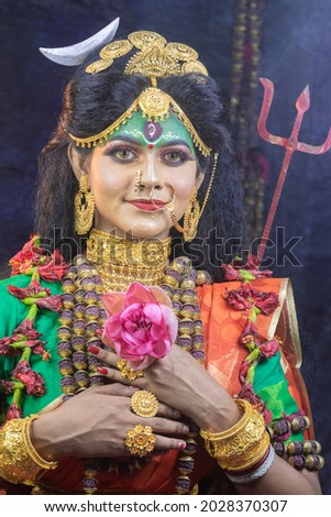 Indian female model in sari and face makeup to resemble Indian  Hindu goddess Uma or parvati is personification of beauty.Embodiment of Love, Power and Renewal.

