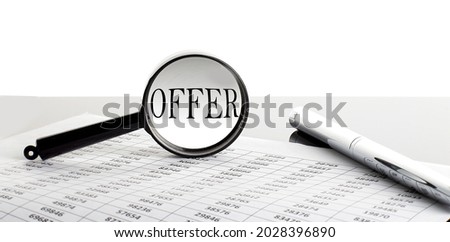 Magnifying glass with text OFFER on background with pen
