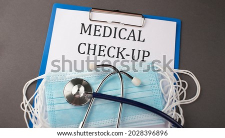 Folder with paper text MEDICAL CHECK-UP , on a table with a stethoscope and medical masks, medical