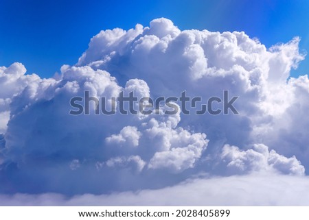 Large white billowy cloud against a light blue sky. Space for copying text Royalty-Free Stock Photo #2028405899