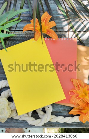 Mock up with two empty space colored notebooks on a wooden table, flat lay, outdoor summer photo with palm shadows and flowers
