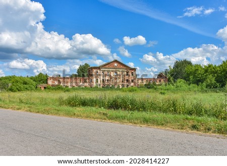 abandoned red brick estate surrounded by greenery against the background of the sky