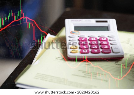 Calculator and document with stock graph down trend on wooden table, financial concept with copy space