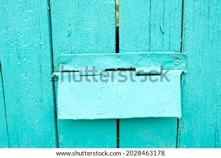 Blue painted old wooden plank fence with a mailbox. Vintage close-up photo