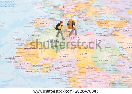 Miniature travellers on the Africa continent of the world map  Royalty-Free Stock Photo #2028470843