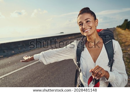 Hitchhiker giving a sign to cars to stop