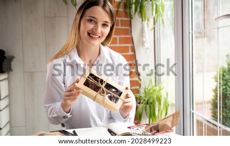 Small business owner. Woman businesswoman presents the goods of the online store in a box to the camera. Delivery and sale of food online. The seller advertises wholesome food. Small business concept
