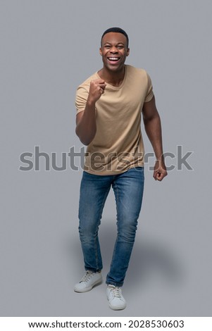 Studio picture of dark-skinned man in a beige tshirt