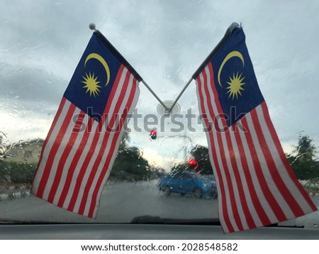 Selective focus of malaysian flag on car mirror, independence day, 31 august, may have grain and noise.