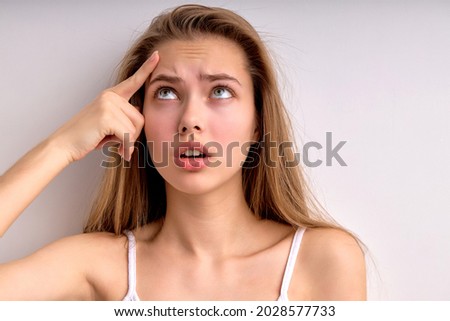 Frustrated young female feeling stressed upset about facial skin problem concept wrinkles or pimple, worried depressed lady touch skin on forehead annoyed by acne, close-up portrait. copy space Royalty-Free Stock Photo #2028577733