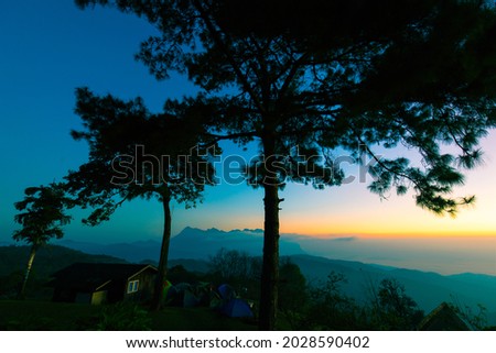 Colorful sky at the morning over mountains in north of Thailand with tents and house at top of mount.