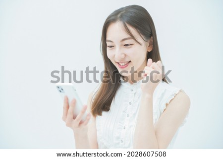 A woman doing a guts pose while looking at the screen of a smartphone