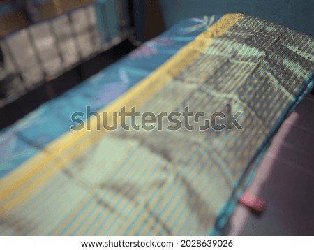 Defocused abstract background of traditional Indonesian textile fabric surface.