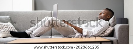 African American Man Shopping Online On Couch