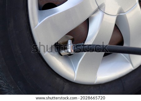 Man calibrating car tire. Selective focus. Royalty-Free Stock Photo #2028665720