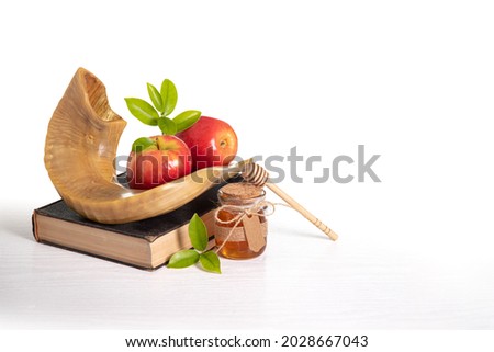 Red apples, Shofar,  honey  Torah book on white background, Rosh Hashanah (Jewish New Year holiday) concept. Royalty-Free Stock Photo #2028667043