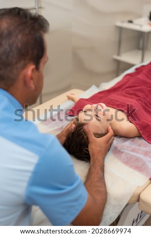 Wellness massage for children. Hands of the masseur close-up. Physiotherapist working with patient in clinic. Vertical photo