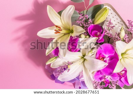 A beautiful bouquet of fresh flowers on a pink background. The festive concept for Weddings, Birthdays, Mother's Day, For Valentine, or March 8th. Greeting card, a place for text, flat lay