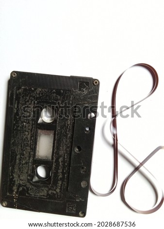black tape cassette on a white background. music, objects, technology, broken cassette