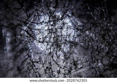 a close-up shot of a hardened ice surface destroyed in cracks and illuminated by light from outside