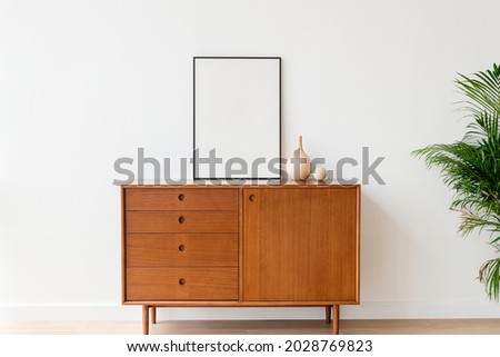 Blank picture frame on a wooden cabinet Royalty-Free Stock Photo #2028769823