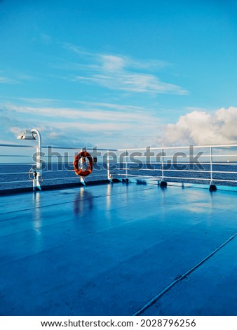 Blue picture of cruise ship deck and ocean with beautiful sky - concept of ferry transport and holiday vacation season