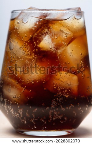 rum with cola and ice in a glass close-up, cola with ice. summer drink