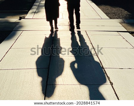 Shadows of men and women walking in the precincts Royalty-Free Stock Photo #2028841574