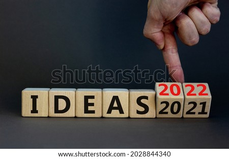 2022 ideas new year symbol. Businessman turns wooden cubes and changes words 'Ideas 2021' to 'Ideas 2022'. Beautiful grey background, copy space. Business, 2022 ideas new year concept.