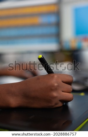 Close up of black designer editing customer client image with stylus pencil, drawing on graphics tablet. Hand of african american woman editor photographer retouching assets working in creative