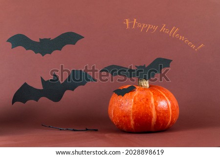 halloween picture with pumpkin and bat against brown background 
