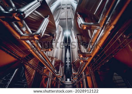 Rows of steel tanks for beer fermentation and maturation in a craft brewery Royalty-Free Stock Photo #2028912122