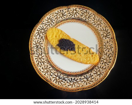 Bread slices with butter and black caviar on a porcelain plate:Use for website banner background,backdrop
