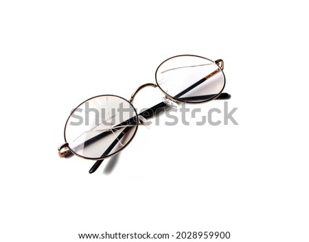 Clear glass eyeglasses fractured on both sides. Because of an accident placed on a white background. Isolated. Royalty-Free Stock Photo #2028959900