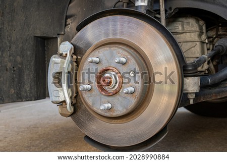 Vehicle brakes parts. Caliper and rotor on car. Brake inspection, repair, service and maintenance concept Royalty-Free Stock Photo #2028990884