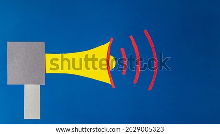 Megaphone on blue background, flat lay. Marketing and advertising concept, paper art.
