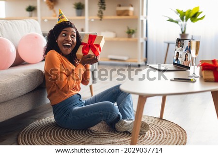 Online Birthday Party. Happy Black Woman At Laptop Receiving Gift From Friends Celebrating B-Day Via Group Video Call At Home. Virtual Holiday Celebration And Presents Delivery Concept