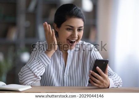 Excited young Indian woman look at cellphone screen shocked by unexpected online sale offer or promotion deal. Overjoyed stunned ethnic female use smartphone get amazing news message on gadget. Royalty-Free Stock Photo #2029044146