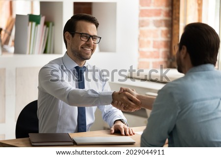 HR manager handshakes company position candidate, selling insurance, professional services. Male entrepreneurs, broker and client shake hands start business meeting in office. Job interview concept Royalty-Free Stock Photo #2029044911